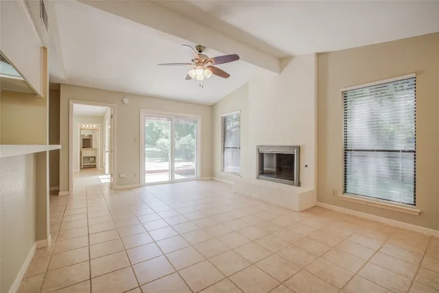 a view of an empty room with a fireplace and a window