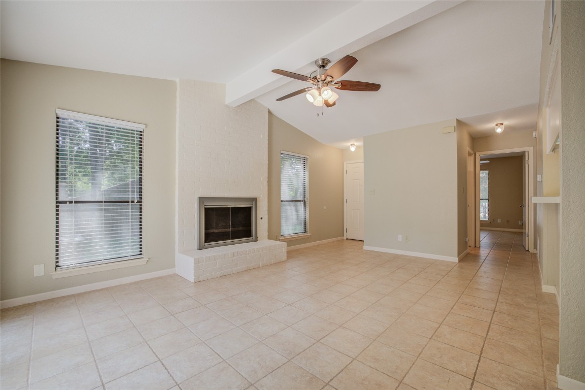 306 Corral Lane, Unit B Austin, TX 78745 - Photo 8 of 33 a view of an empty room with a fireplace and a window