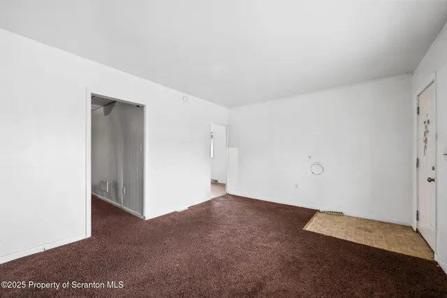 an empty room with windows and closet