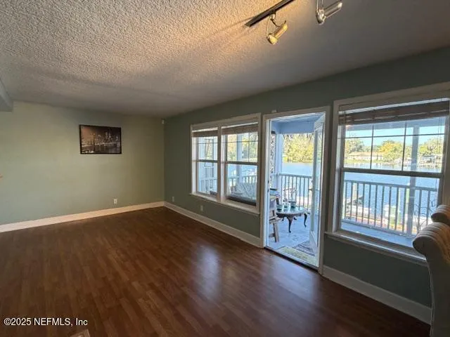 an empty room with large window and wooden floor