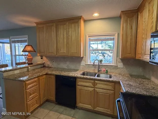 a kitchen with stainless steel appliances granite countertop a refrigerator a stove and a wooden cabinets