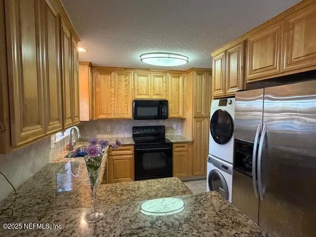 a kitchen with stainless steel appliances granite countertop a stove microwave and refrigerator