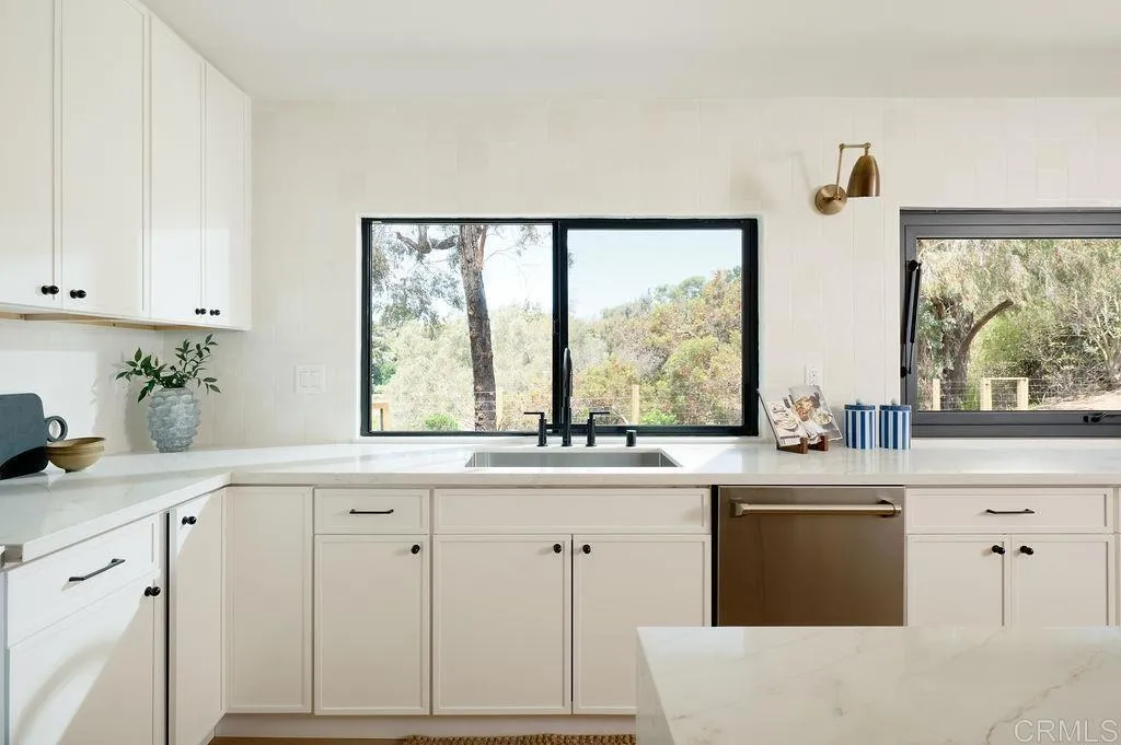 2025 Valley Road Oceanside, CA 92056 - Photo 8 of 31 a kitchen with white cabinets and a large window