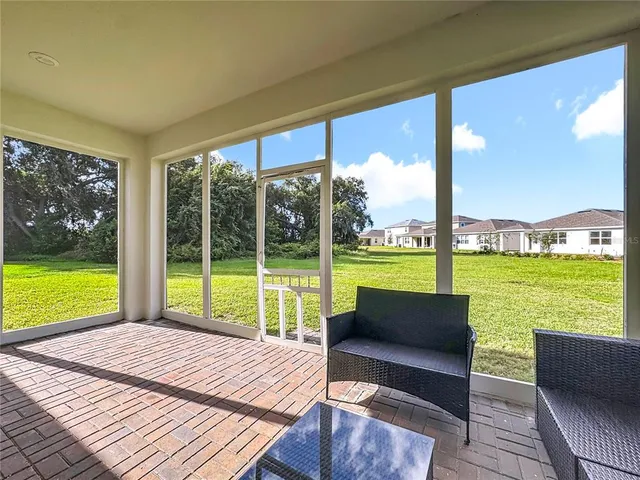 a view of a big house with a big yard and large trees