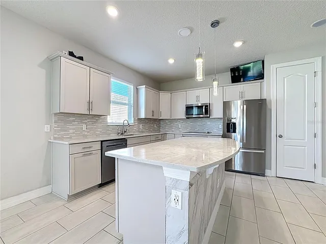 a kitchen with stainless steel appliances granite countertop refrigerator sink and cabinets