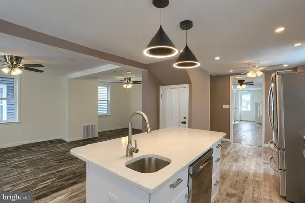 a kitchen with stainless steel appliances granite countertop a sink and a refrigerator