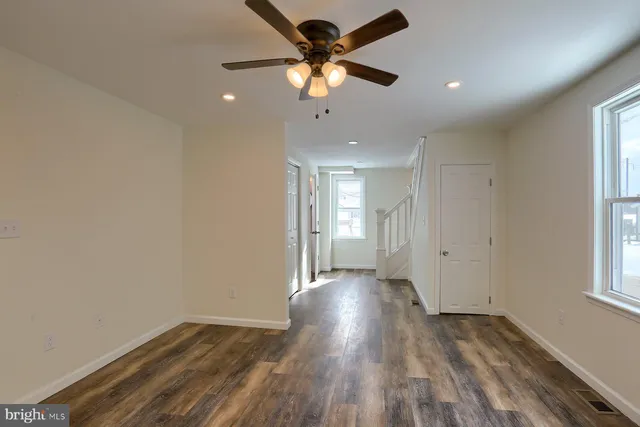 a view of an empty room with windows and closet