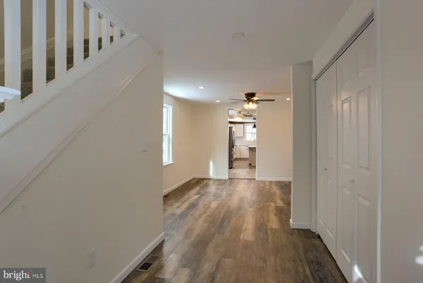 a view of a hallway with wooden floor and staircase