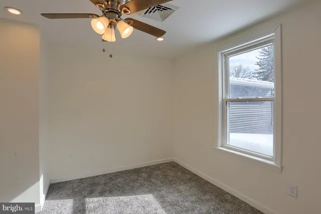a view of a livingroom with a ceiling fan and window