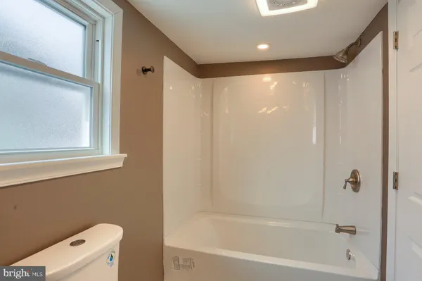 a bathroom with a bathtub a toilet and a shower