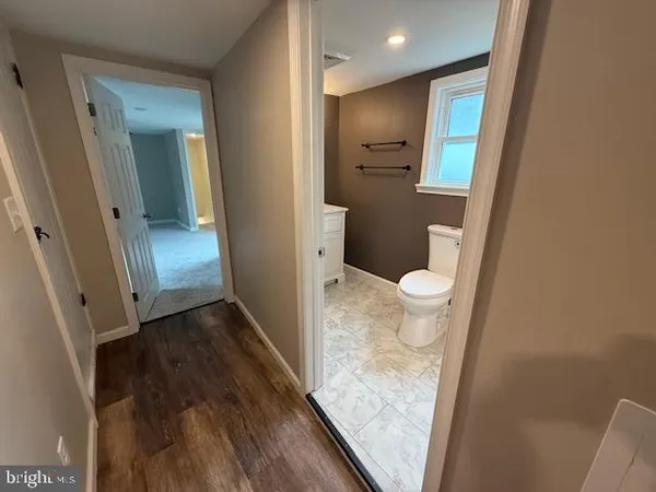 a white toilet sitting next to a bathroom sink and a window