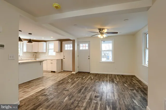 a view of a kitchen with wooden floor and a window