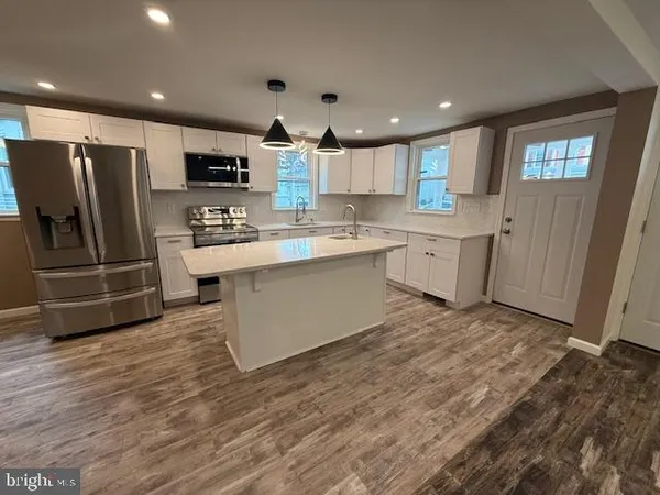a kitchen with stainless steel appliances a refrigerator sink and microwave