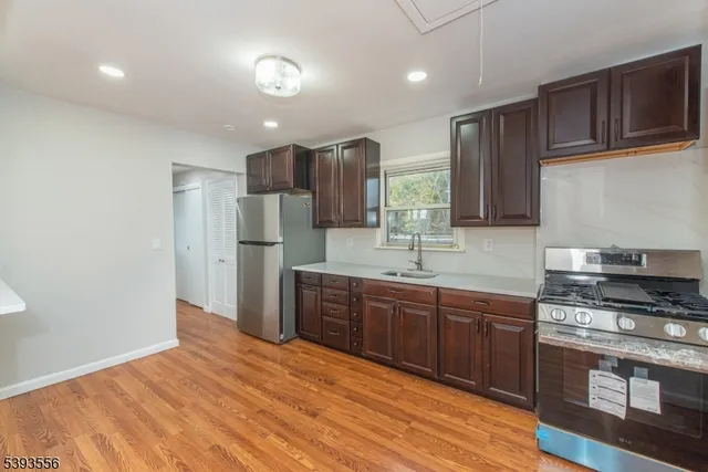 a kitchen with stainless steel appliances granite countertop a refrigerator and a stove top oven