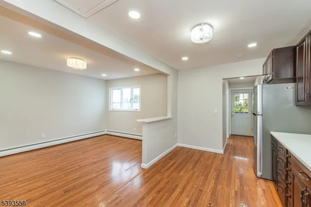 a view of empty room with wooden floor