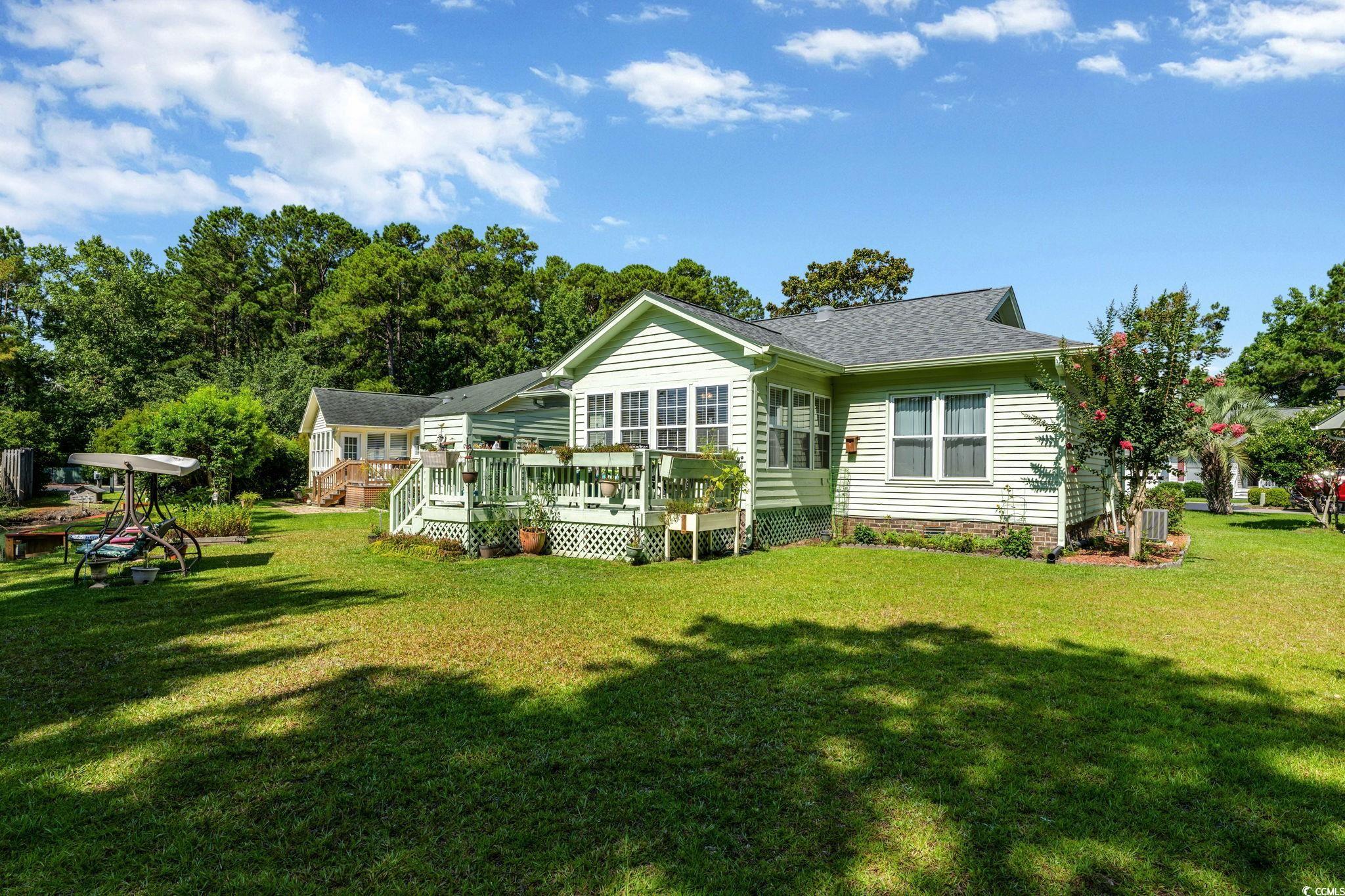 1305 Conifer Court Murrells Inlet, SC 29576 - Photo 21 of 30 Rear view of property featuring a lawn and a woode