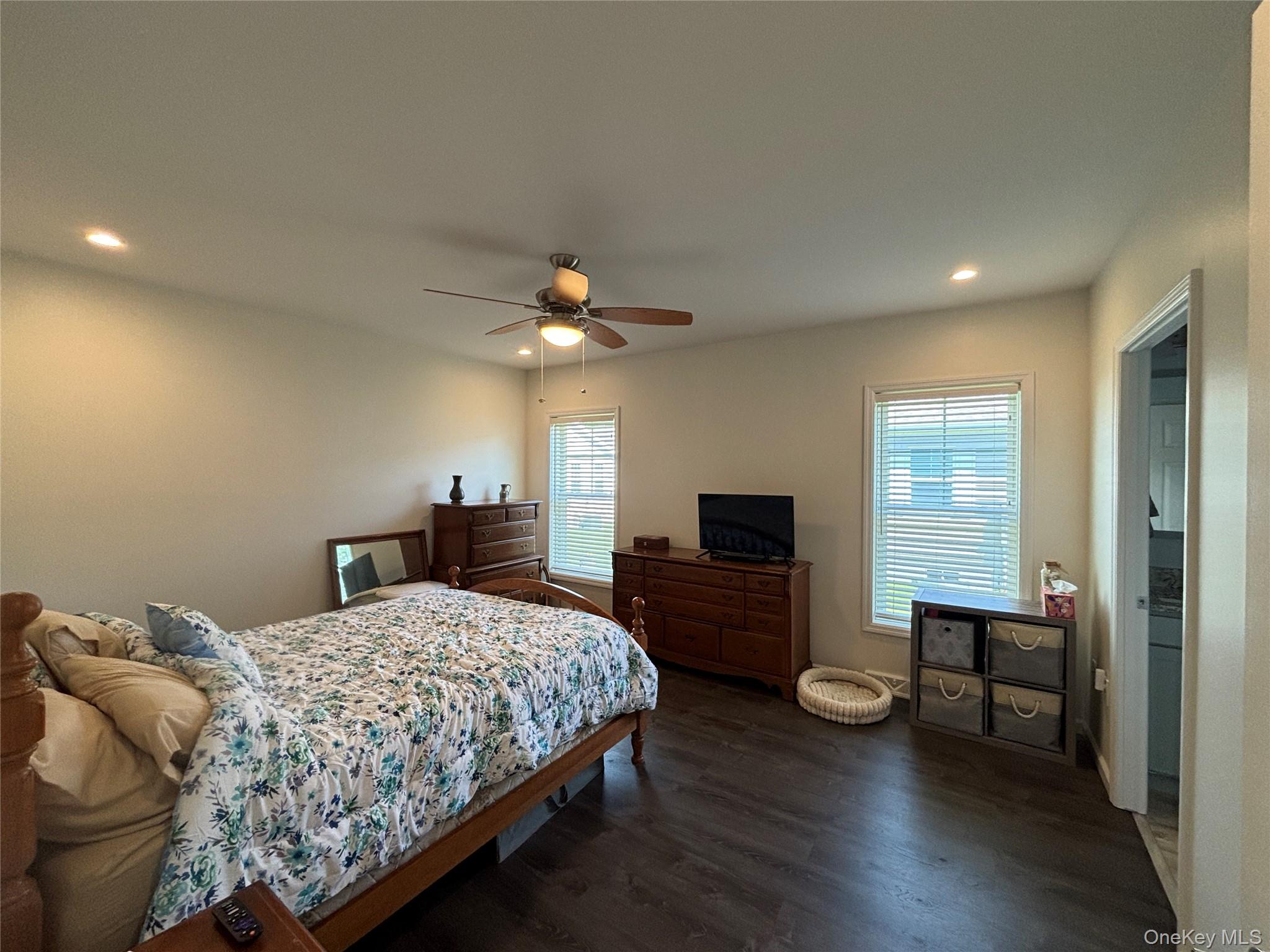 1661 Old Country Road, Unit 563 Riverhead, NY 11901 - Photo 27 of 43 a bedroom with a bed and a chandelier