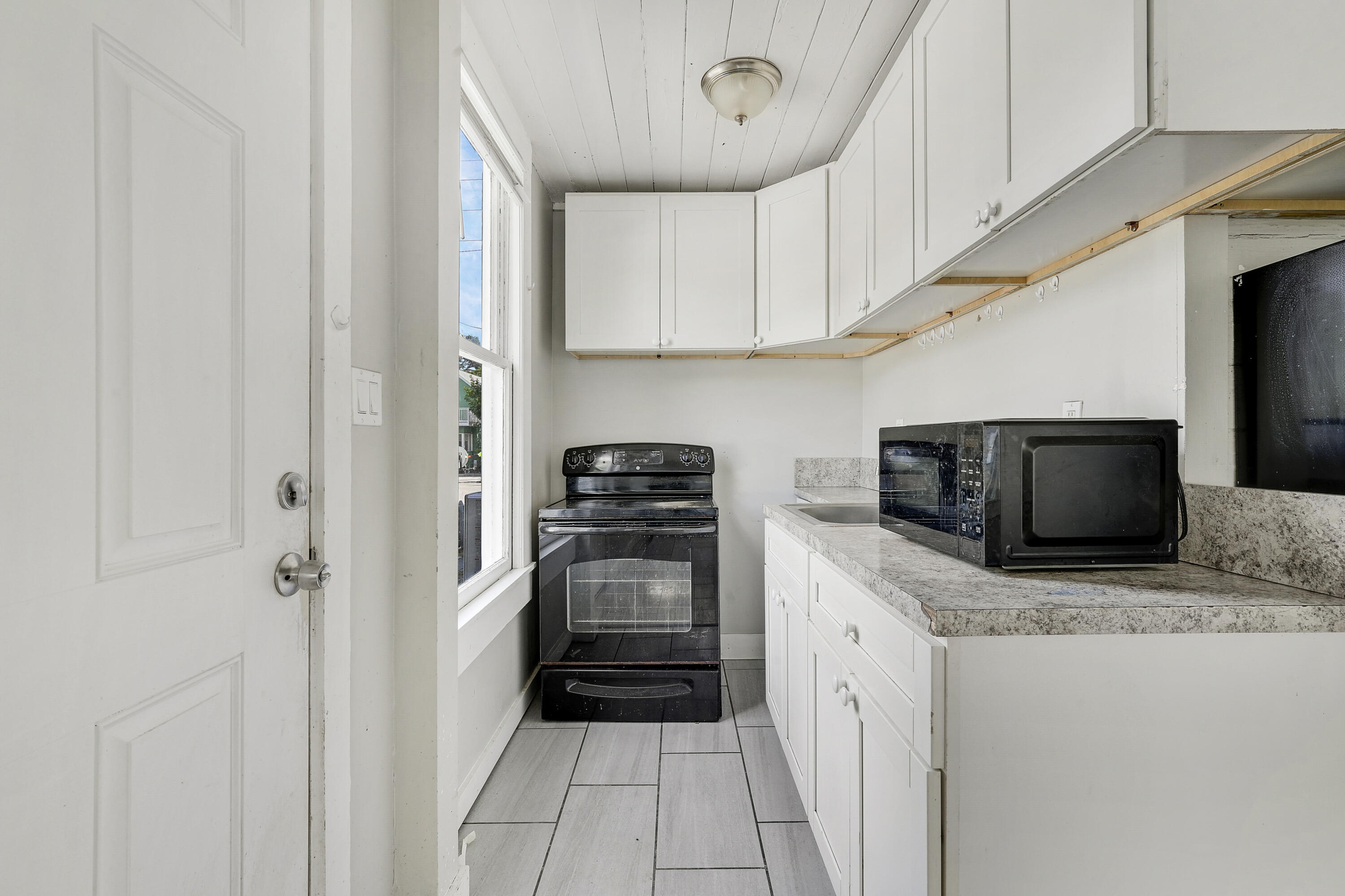301 South 7th Street Fort Pierce, FL 34950 - Photo 9 of 15 a kitchen with stainless steel appliances a stove microwave and cabinets