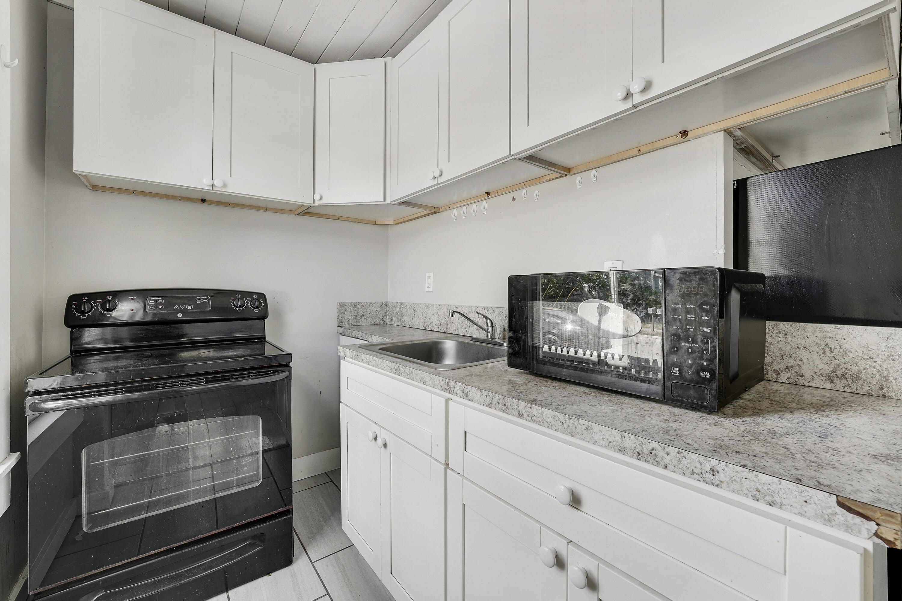 301 South 7th Street Fort Pierce, FL 34950 - Photo 10 of 15 a kitchen with granite countertop white cabinets and white appliances