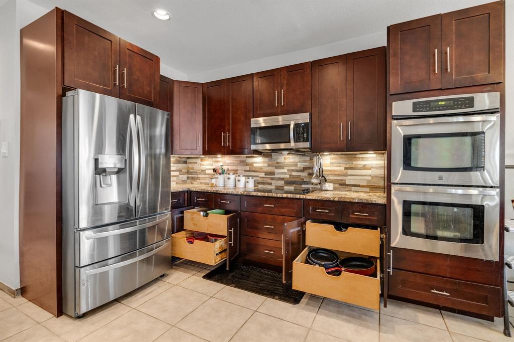 4029 Bridge Water Road Heartland, TX 75126 - Photo 3 of 39 a kitchen with granite countertop stainless steel appliances and wooden cabinets
