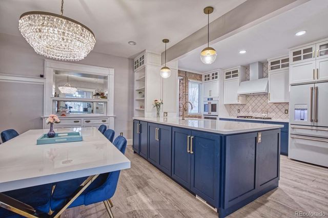 a kitchen with stainless steel appliances granite countertop a sink a stove and a wooden floors