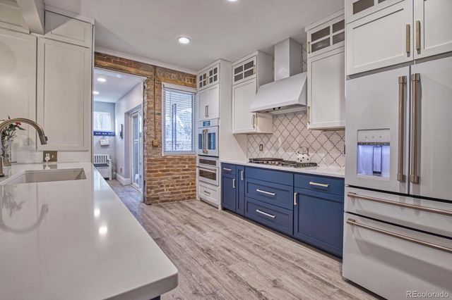 a large kitchen with kitchen island white cabinets and stainless steel appliances