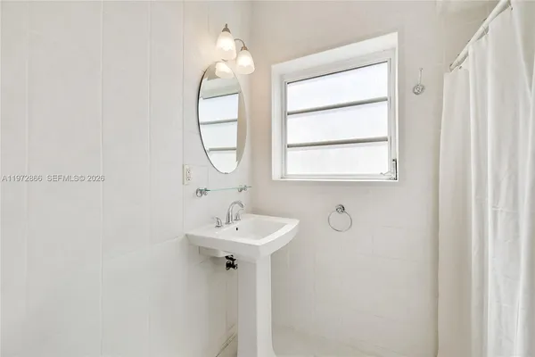 a bathroom with a sink a mirror and a window