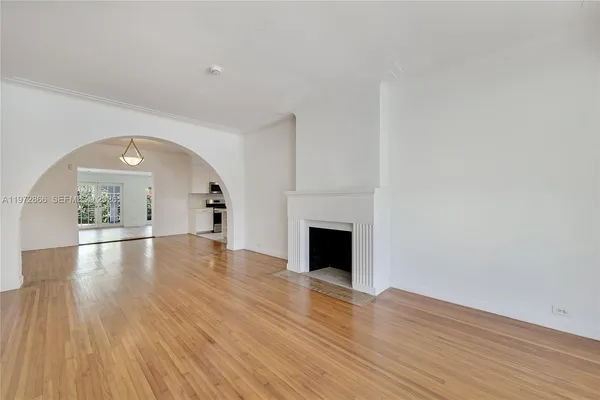 a view of empty room with wooden floor and fireplace