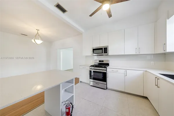 a kitchen with stainless steel appliances and white cabinets