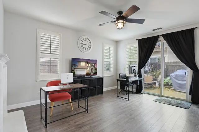 a living room with furniture and a flat screen tv with wooden floor