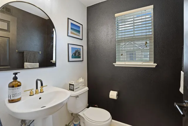 a bathroom with a toilet a sink and mirror