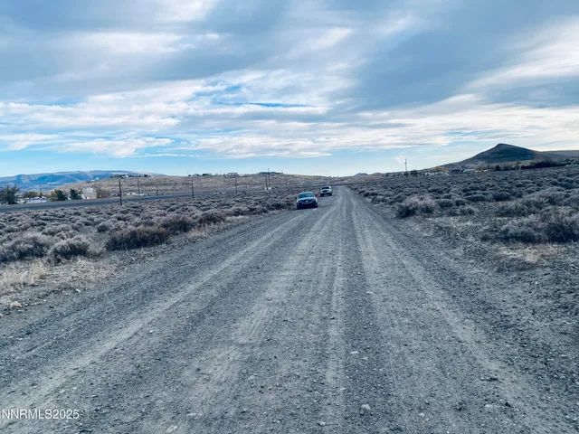 a view of a dry yard with wooden fence