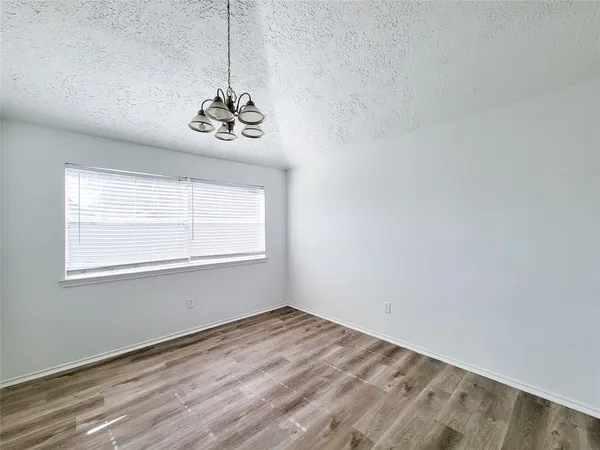 a view of a room with wooden floor and hallway