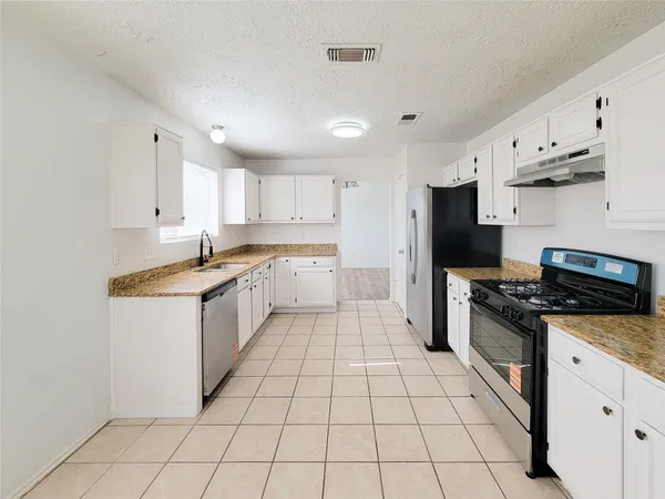 a kitchen with a sink a refrigerator and cabinets