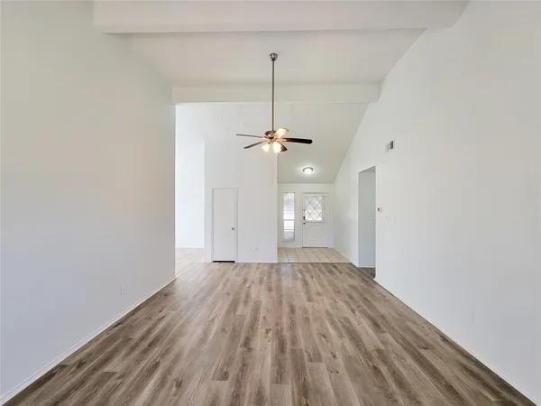a view of a room with a ceiling fan and a wooden floor