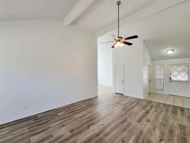 a view of a room with a window and wooden floor
