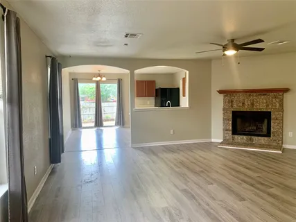 wooden floor fireplace and windows in an empty room