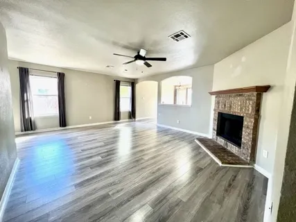 an empty room with windows and a fireplace