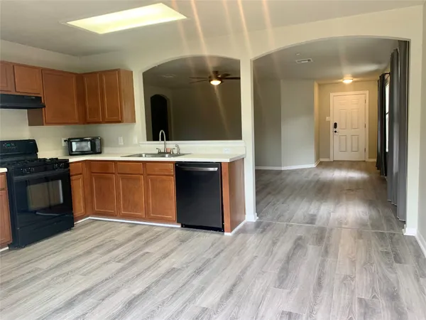 a view of kitchen with wooden floor and electronic appliances