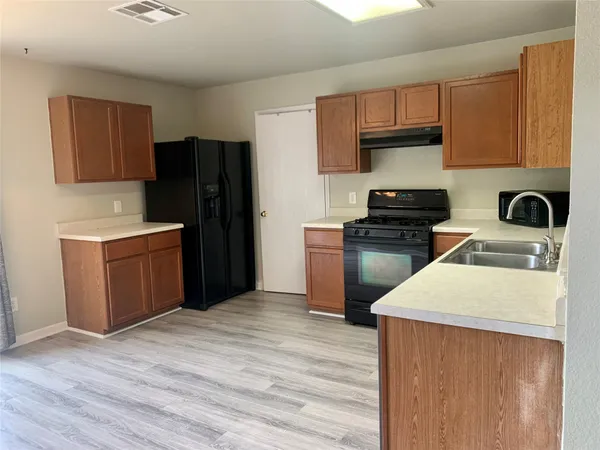 a kitchen with a refrigerator sink and cabinets