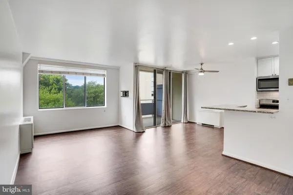 a kitchen with stainless steel appliances granite countertop a sink a stove a refrigerator and a microwave