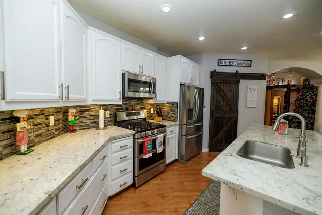 a kitchen with stainless steel appliances granite countertop a sink stove microwave and cabinets
