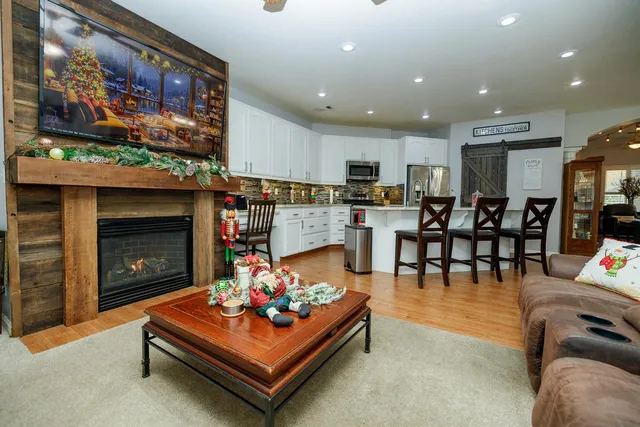 a living room with furniture kitchen view and a large window