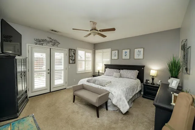 a bedroom with a large bed a flat tv screen and dresser