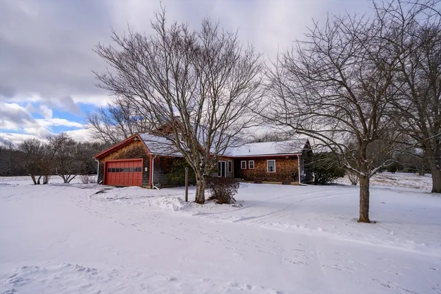 a street view covered with snow in front of house