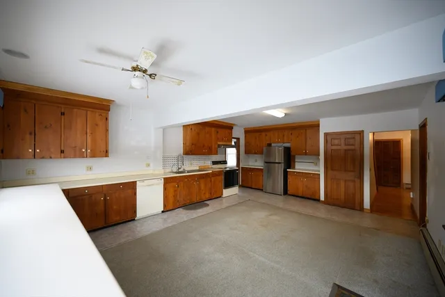 a large kitchen with a large counter top cabinets and stainless steel appliances