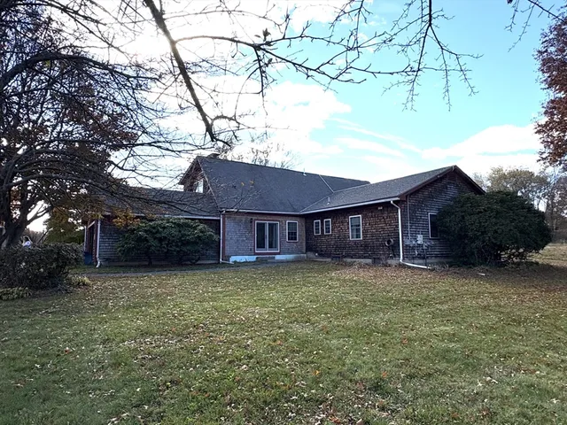 a view of a yard in front of a house with large tree