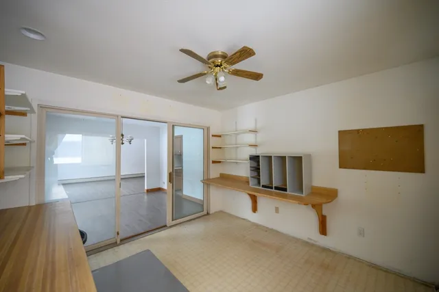 a view of workspace with wooden floor and a ceiling fan