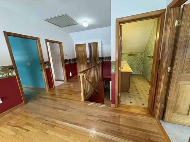 a view of a hallway with wooden floor and windows