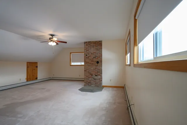 a view of an empty room with chandelier fan